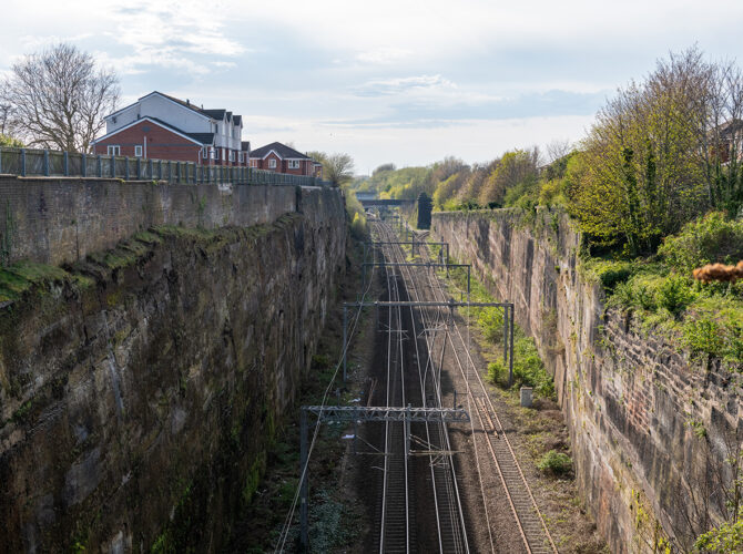 Looking along the deep sandstone cutting towards Swan Bridge, showing the scale of the excavation created for the pioneering railway.