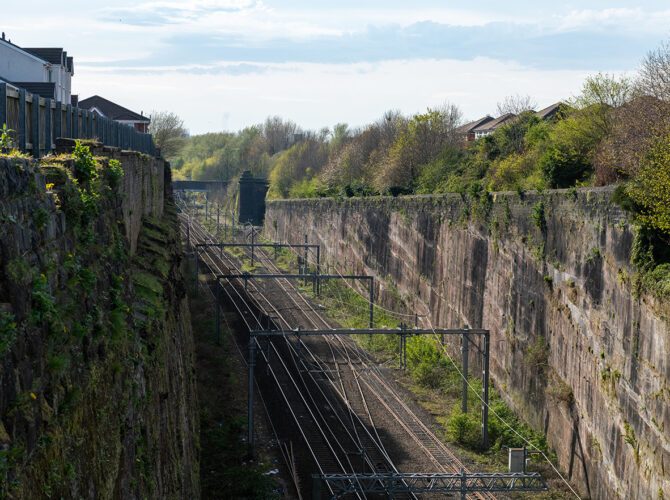 A long view along Olive Mount Cutting, with sheer sandstone walls carrying the railway through one of the Liverpool and Manchester Railway's greatest engineering works.