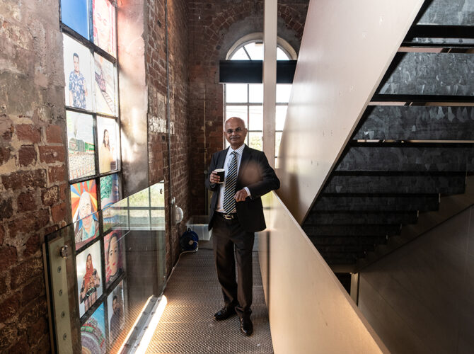Friends Group member standing in front of the artwork installed in one of Edge Hill Station’s arched windows.